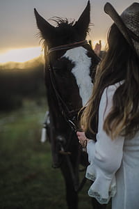 woman wearing white dress holding a horse thumbnail