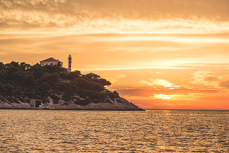 lighthouse on seacliff under golden hour thumbnail