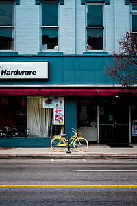 yellow cruiser bike in front of building thumbnail
