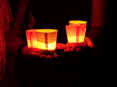 person holding four lighted candles thumbnail