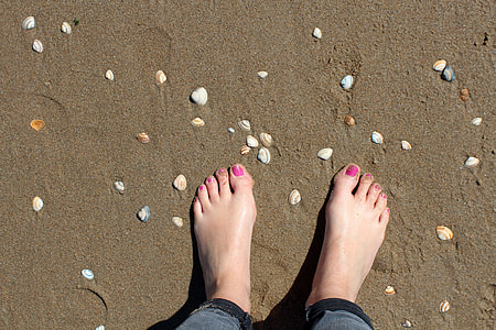 person wearing gray pants standing on sand thumbnail