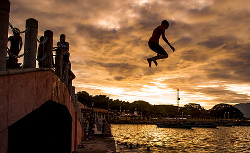 boy jumping on body of water at sunset thumbnail
