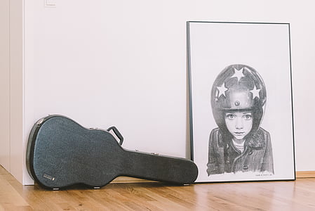 black guitar case beside portrait sketch thumbnail