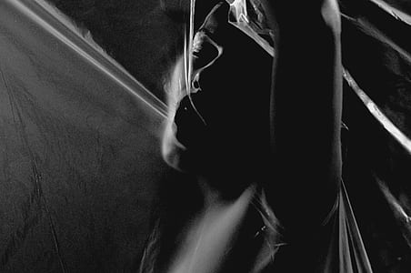grayscale photography of woman lying on bed thumbnail
