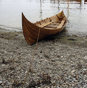 brown wooden boat on seashore at daytime thumbnail