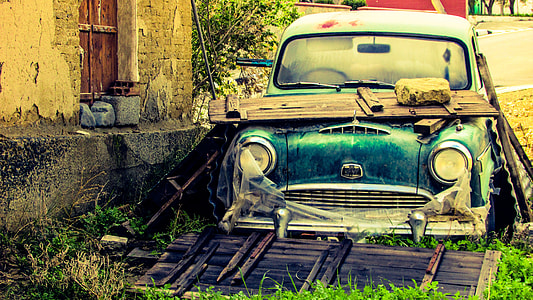 abandoned blue car by the house during daytime thumbnail
