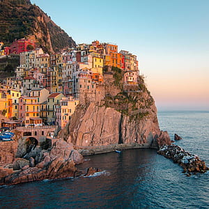 assorted-color concrete houses on cliff thumbnail