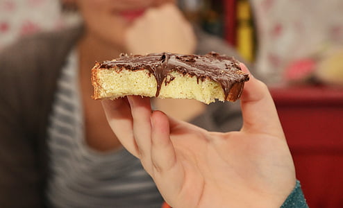 person holding sandwich with chocolate syrup thumbnail