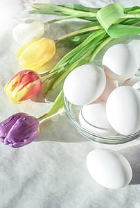 assorted-color petaled flowers and eggs on white textile thumbnail
