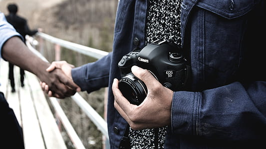 man holding Canon camera thumbnail