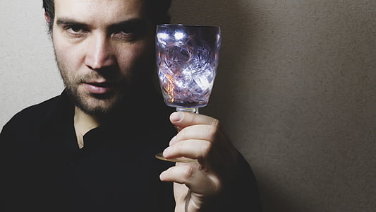 man in black top holding purple translucent drinking glass thumbnail
