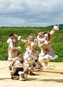 four children dancing near grass field at daytime thumbnail