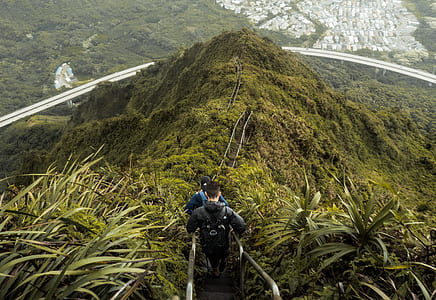people crossing metal pathway on mountain hills thumbnail