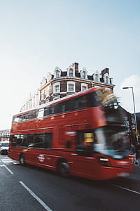 photo of double-deck bus near brown building during daytime thumbnail