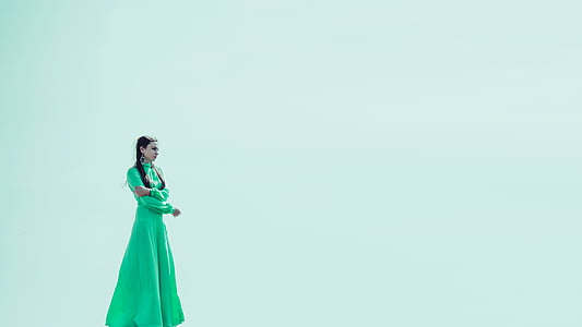 woman wearing green gown standing facing right direction thumbnail