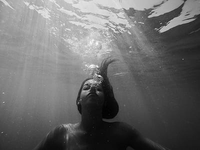 grayscale photo of woman submerged on body of water thumbnail