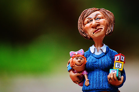 woman holding baby and toy blocks figurine thumbnail