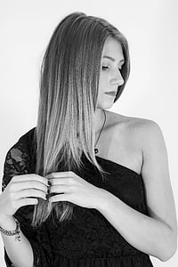 woman in black one-shoulder long-sleeved top while holding her hair and looking beside thumbnail