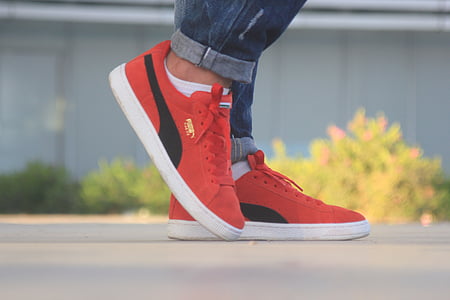 person wearing pair of red Puma shoes thumbnail