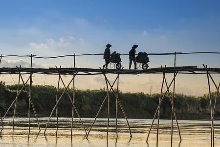 silhouette of person on top of wooden bridge during daytime thumbnail
