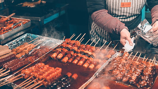 photo of person holding tissue in front of barbecue street foods thumbnail