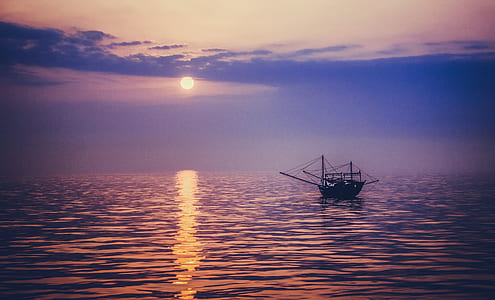 silhouette photo of boat on body of water sailing during dawn thumbnail