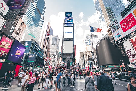 people gathered on the street surrounded by buildings thumbnail