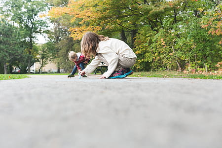 Kids Draw With Chalk On Sidewalk Photo thumbnail