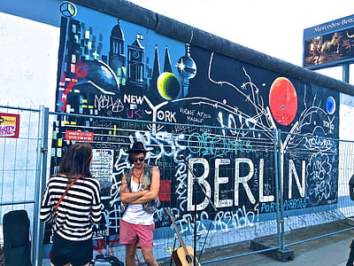 man and woman standing beside blue Berlin painted wall thumbnail