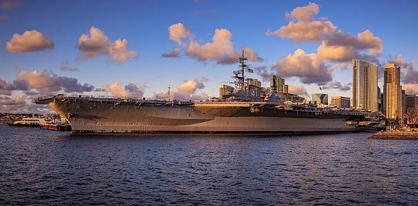 gray vessel on calm body of water under white and blue cloudy sky at daytime thumbnail