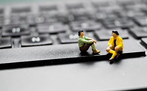 two plastic figures on black laptop keyboard thumbnail
