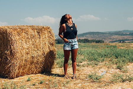 woman in black tank top near hay during daytime thumbnail