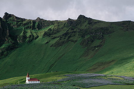 white and brown cathedral and green grass mountain thumbnail
