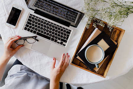A woman works at a desk with a laptop and a cup of coffee thumbnail