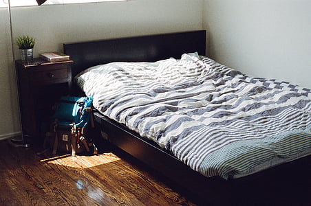 brown wooden bed frame with gray mattress thumbnail