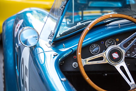 person beside blue car thumbnail