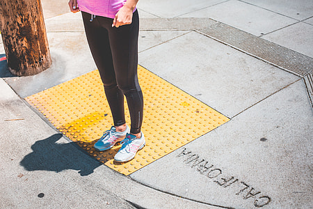 Young Female Jogger Waiting at the Edge of a Zebra Crossing thumbnail