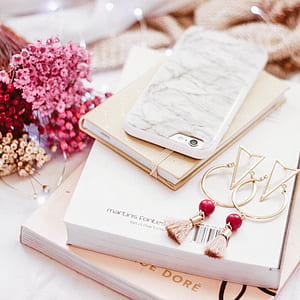 tilt shift photography of white smartphone case on top of book thumbnail