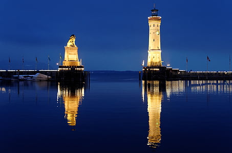 beige concrete lighthouse beside lion monument near body of water thumbnail