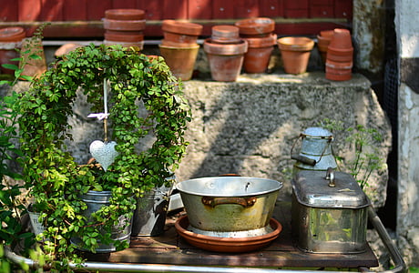 round silver tub beside silver stockpot on brown wooden table thumbnail
