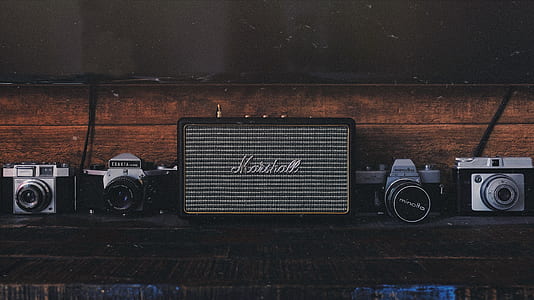 minimalist photography of DSLR cameras and guitar amplifier thumbnail