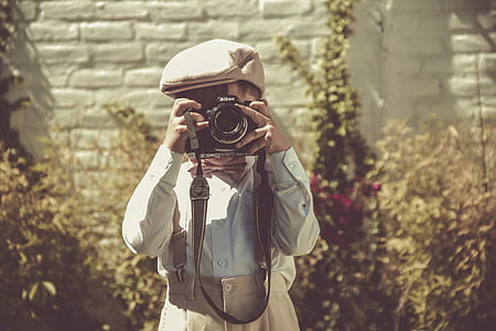 boy holding camera and taking photo thumbnail