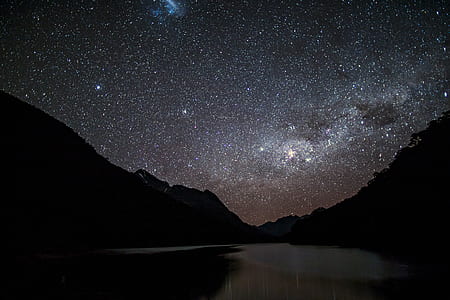 body of water in the middle of mountains and stars thumbnail