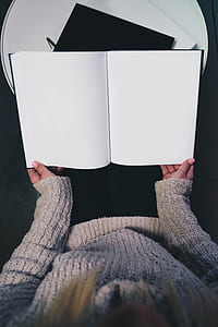 woman holding white book thumbnail