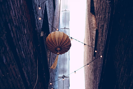 brown lantern hanging on string lights thumbnail