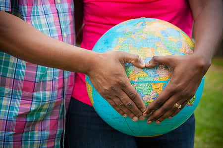 person wearing pink top holding globe thumbnail