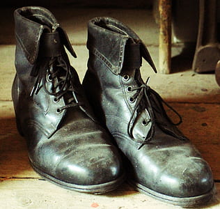 black leather combat boots on brown wooden surface thumbnail