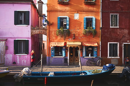 boat near brown and pink concrete buildings thumbnail