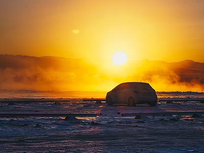 white vehicle in an open field at golden hour thumbnail