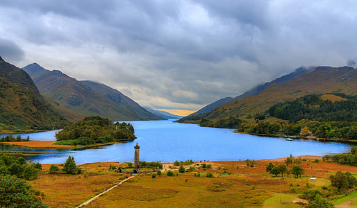 body of water within mountain range during daytime thumbnail